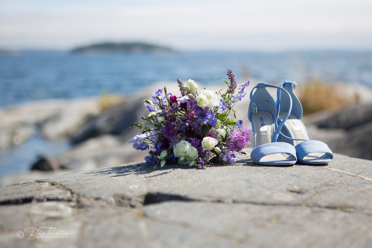 bröllopsskor och brudbukett vid havet